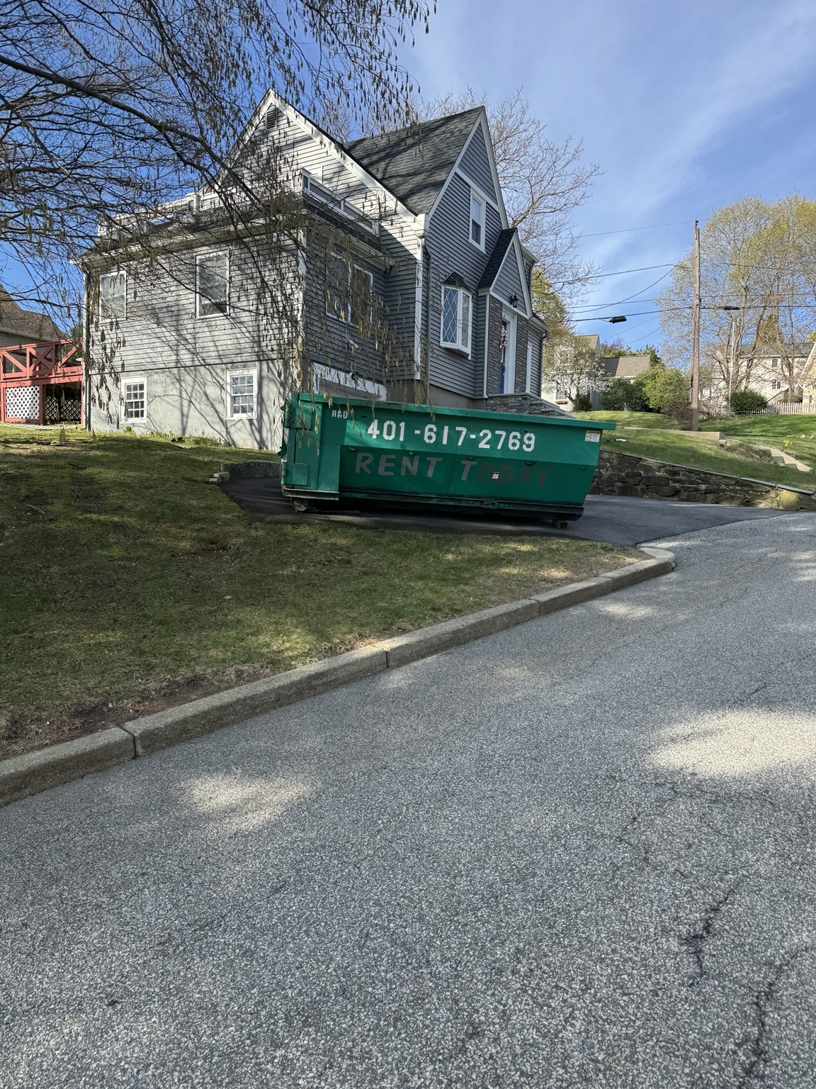 Green 15 yard R&D rental dumpster at a residential property